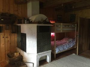 ein Schlafzimmer mit einem Etagenbett und einem Kamin in der Unterkunft Cozy Log Cabin near Faaker See in Ledenitzen