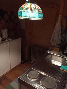 a kitchen with a sink and a stained glass light at Cozy Log Cabin near Faaker See in Ledenitzen