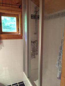 y baño con ducha y ventana. en Cozy Log Cabin near Faaker See en Ledenitzen
