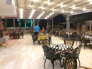 un homme debout dans un restaurant avec des tables et des chaises dans l'établissement Sen Apart, à Turunç