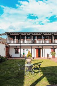 a house with a table and chairs in the yard at Casona Quesada in Suesca