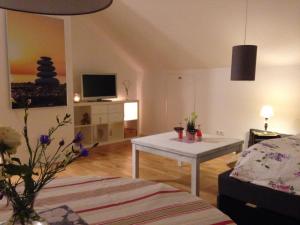 a living room with a white table and a tv at Gemütliche, großzügige Ferienwohnung in Salzhausen