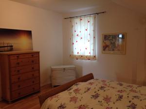 a bedroom with a bed and a dresser and a window at Gemütliche, großzügige Ferienwohnung in Salzhausen