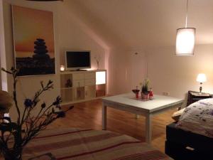 sala de estar con mesa y TV en Gemütliche, großzügige Ferienwohnung, en Salzhausen