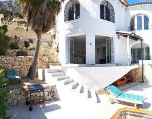 a white house with stairs and a palm tree at villa Grace,10p,seaview,pool in Calpe