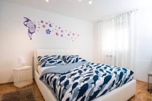 a bedroom with a bed with a blue and white comforter at Oasis of Peace and Relaxation near Opatija in Matulji