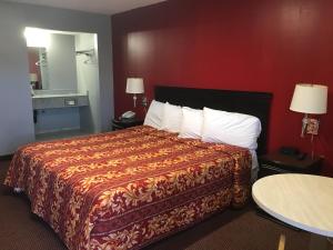 una camera d'albergo con un letto con una parete rossa di Journeys End Motel ad Absecon