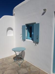 Una mesa y una ventana en una pared blanca. en Fortina Mykonos house, en Klouvas