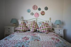 a bedroom with a bed with pillows and clocks on the wall at Maggies Cottage in Bushmills