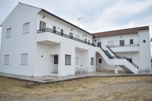 Un edificio blanco con una escalera al costado. en MemSoares Country House, en Castelo de Vide