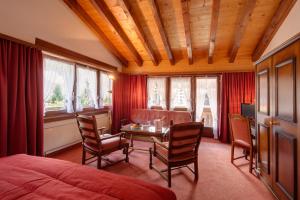 una camera con letto, tavolo e sedie di Hotel Astoria a Zermatt