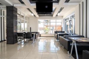 a restaurant with tables and chairs and a flat screen tv at Piano Guesthouse in Adler