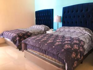 1 dormitorio con 2 camas y cabecero azul en Santa Fe Hotel Boutique, en Tapachula