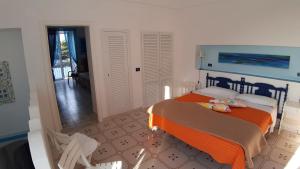 a bedroom with a bed with an orange blanket at Villa Glicine in Ponza