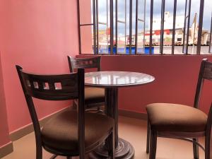 a table and chairs in a room with a window at Santa Fe Hotel Boutique in Tapachula