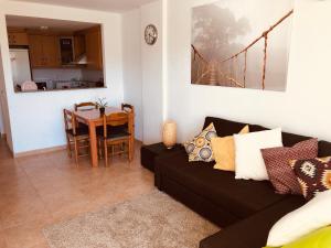 ein Wohnzimmer mit einer schwarzen Couch und einem Tisch in der Unterkunft Apartamento Solmar in Peñíscola