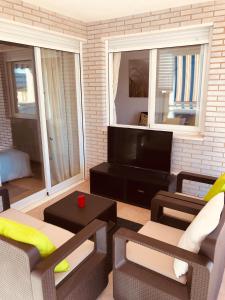 ein Wohnzimmer mit Couch und Fernseher in der Unterkunft Apartamento Solmar in Peñíscola