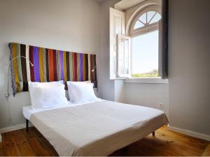 a bedroom with a white bed with a window at Train Spot Guesthouse in Marvão