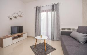 un soggiorno con divano, TV e tavolo di Apartments Kekel a Biograd na Moru