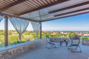 a patio with two chairs and a table at Eco Villa Makri in Makri