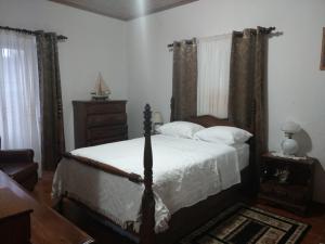 a bedroom with a bed and a dresser at Pandora in Faja Grande