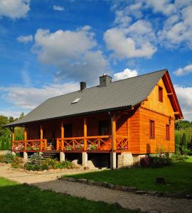 a large wooden house with a gambrel roof at Skrawek Nieba in Ropa