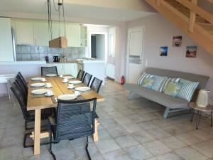 a dining room with a table and chairs and a couch at Dip In The Blue - 1 in Agios Georgios