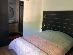 - une chambre avec un lit doté d'une tête de lit noire et d'un lavabo dans l'établissement Euskal etxea, à Bayonne