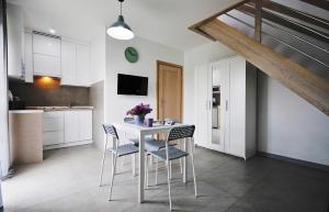 a kitchen and dining room with a table and chairs at Zatoka Wypoczynku Grzybowo - Apartamenty dwupoziomowe in Grzybowo