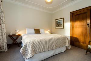 um quarto com uma cama e um armário de madeira em Deco Villa em Havelock North