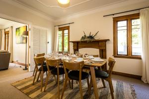 een eetkamer met een tafel en stoelen en een open haard bij Deco Villa in Havelock North