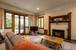 a living room with a couch and a fireplace at Deco Villa in Havelock North