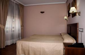 a hotel room with a bed and a window at Hotel Restaurante Casa Pipo in Tuña