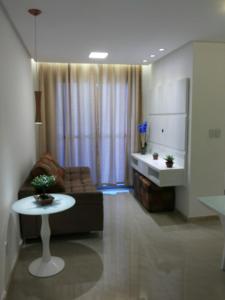 een woonkamer met een bank en een tafel bij APTº NOVO NO SANTA LÚCIA in Aracaju
