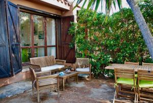 un patio con mesa, sillas, mesa y bancos en Villa Bianca, en Capitana