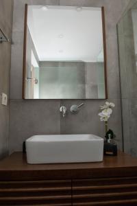 een badkamer met een witte wastafel en een spiegel bij Urban 35 in Chania +32 foto's