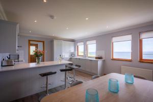 a kitchen with a table and a counter with stools at Taste of the Sea in Staffin