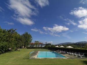 a swimming pool in a yard with chairs and a house at Quinta da Casa Alta in Valença
