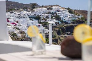 a view of a city from a balcony with white buildings at Ambition Suites in Oia