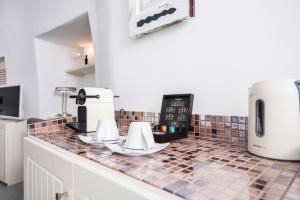 a kitchen area with a microwave and a coffee maker at Ambition Suites in Oia