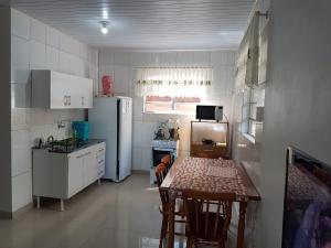 uma pequena cozinha com uma mesa e um frigorífico em Residencial Gurtler 209 em Gramado