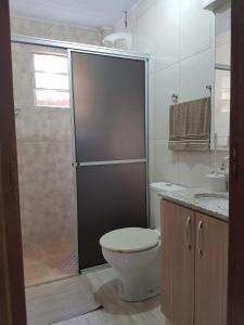 een badkamer met een douche, een toilet en een wastafel bij Residencial Gurtler 209 in Gramado