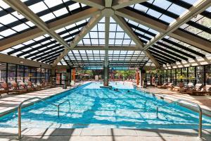 una gran piscina con sillas y un gran techo en Condos at Canyons Resort by White Pines, en Park City