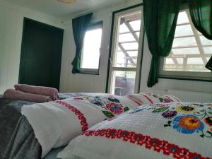 1 dormitorio con 1 cama con mantas de colores y ventana en Willa Wiślok en Wisła