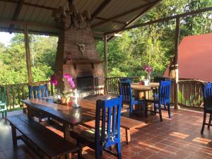 a patio with a wooden table and chairs and a fireplace at La Casa del Rio B&B in Puyo
