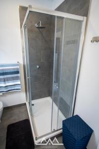 La salle de bains est pourvue d'une douche avec une porte en verre. dans l'établissement White House II, à Praia da Vitória