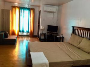 a living room with a bed and a television at BUDGET FRIENDLY CONDO-STUDIO UNIT in Cebu City