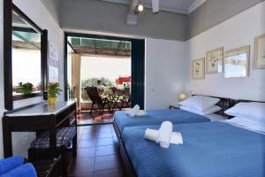 バルバティにあるBarbati Beach Houseのベッド2台とバルコニーが備わるホテルルームです。