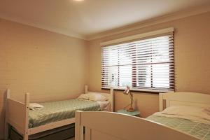 a small room with two beds and a window at Jodi's Beach Retreat Eden in Eden