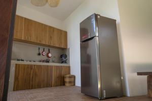 a stainless steel refrigerator in a kitchen with wooden cabinets at Kak Poleng Guesthouse in Canggu